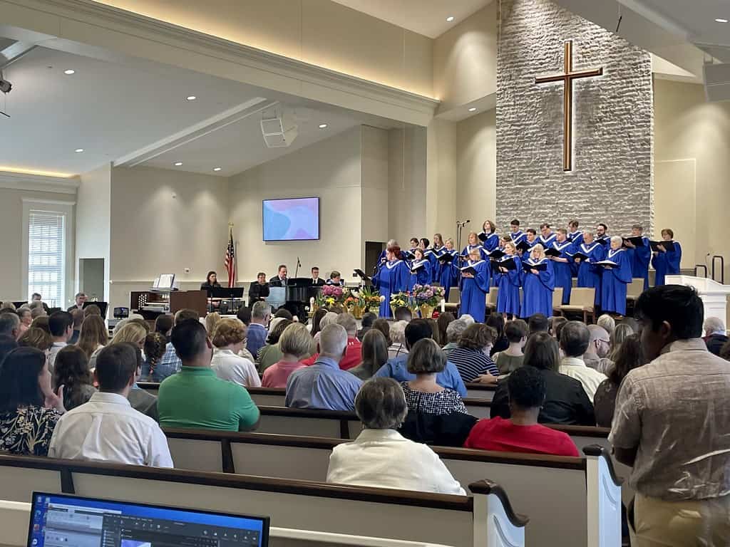 Easter choir performance at New Albany United Methodist Church with congregation and church interior.